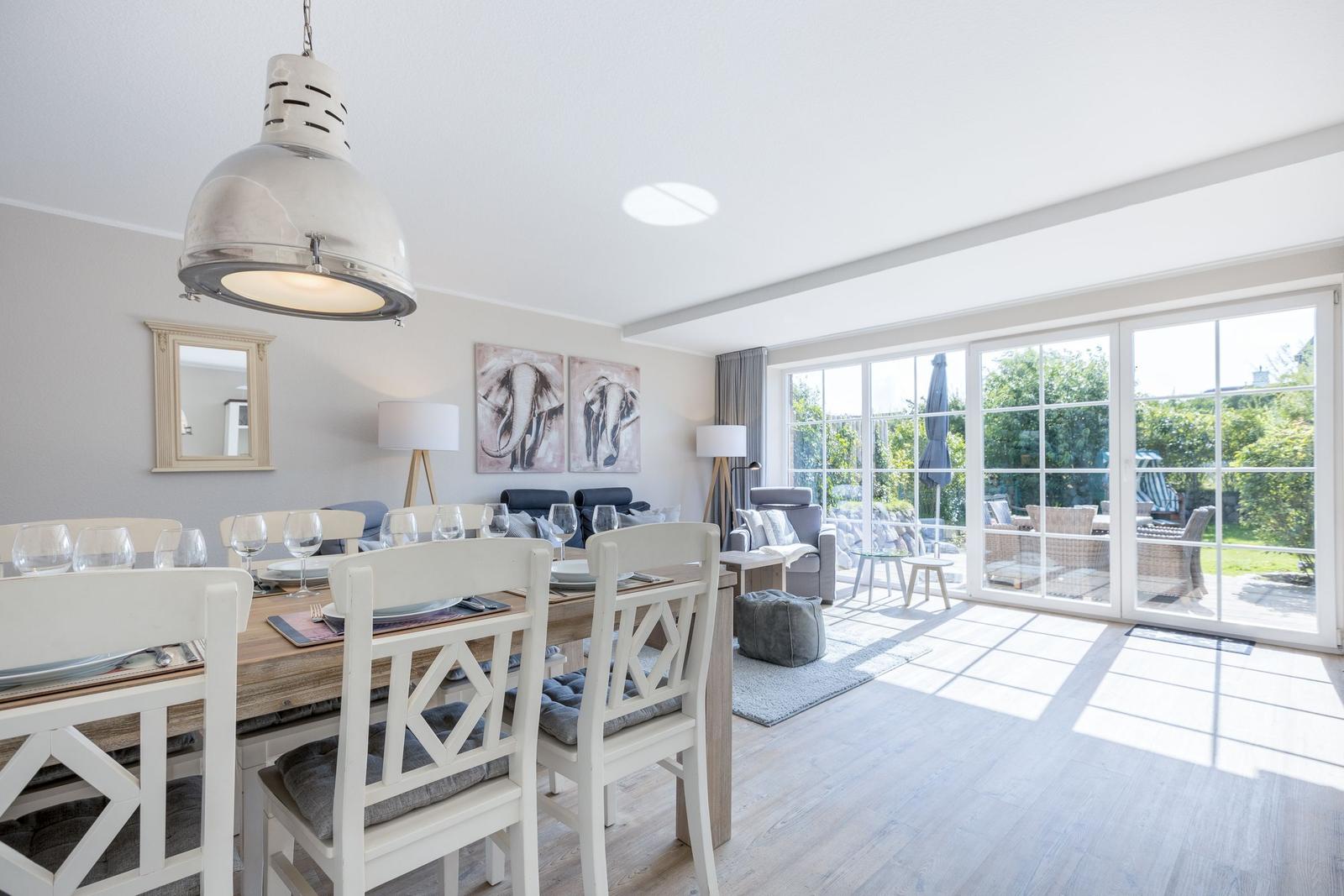 Dining area with table and chairs, living area with sofa and view of the garden.