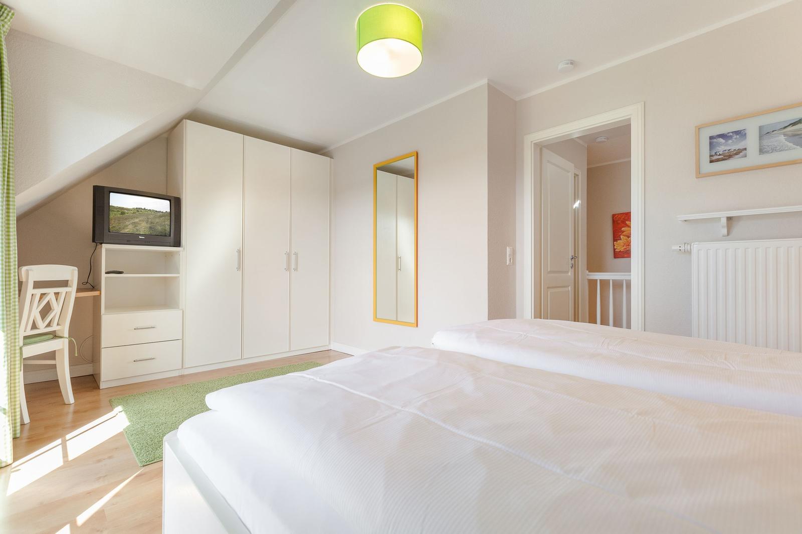 Bedroom with double bed, wardrobe, TV, and mirror.
