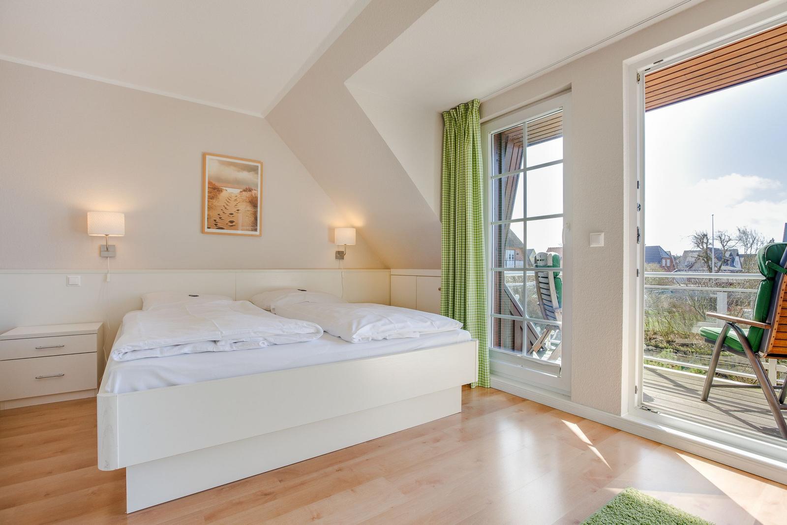 Bedroom with double bed, balcony, and green curtains.