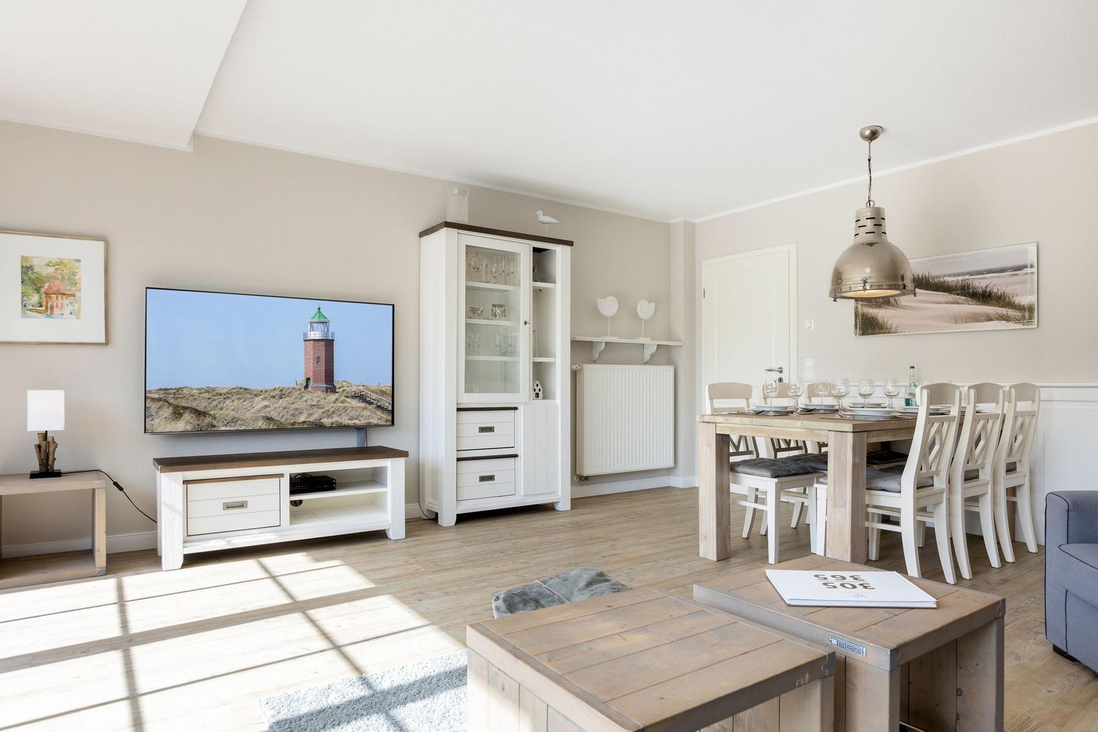 Living and dining area with TV, dining table, and sideboard.
