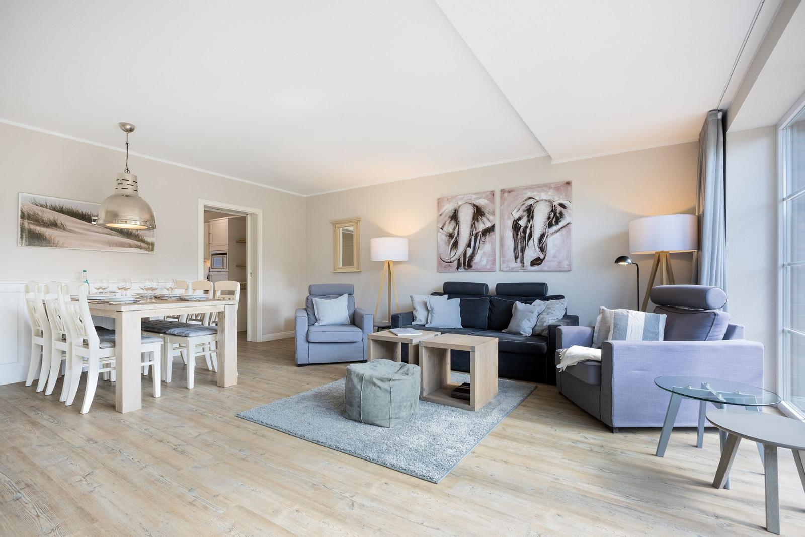 Living and dining area with sofa, armchairs, and dining table.