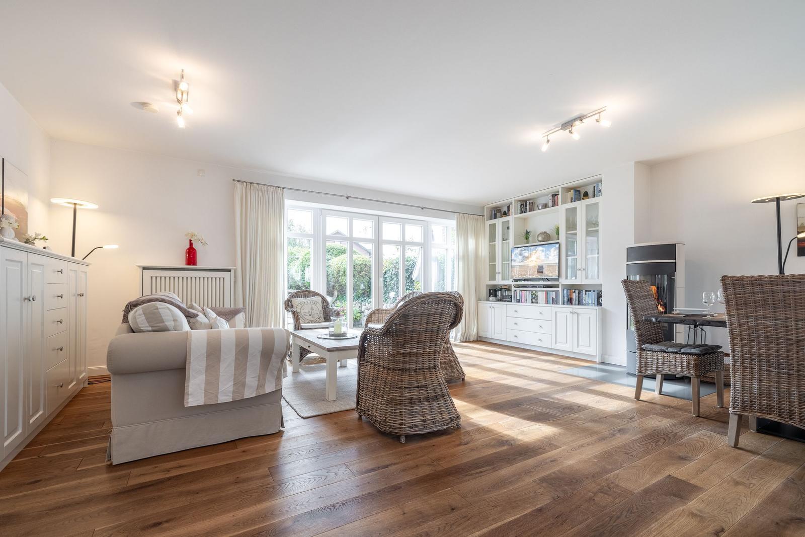 Living room with wooden floor, seating, and television.