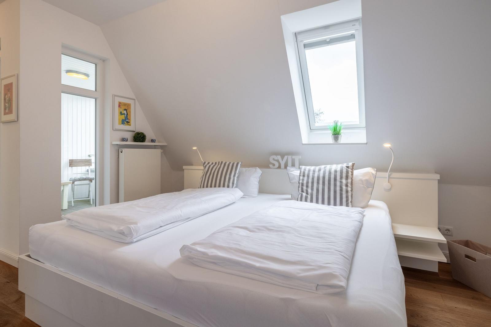 Bedroom with double bed, skylight, and view of balcony.