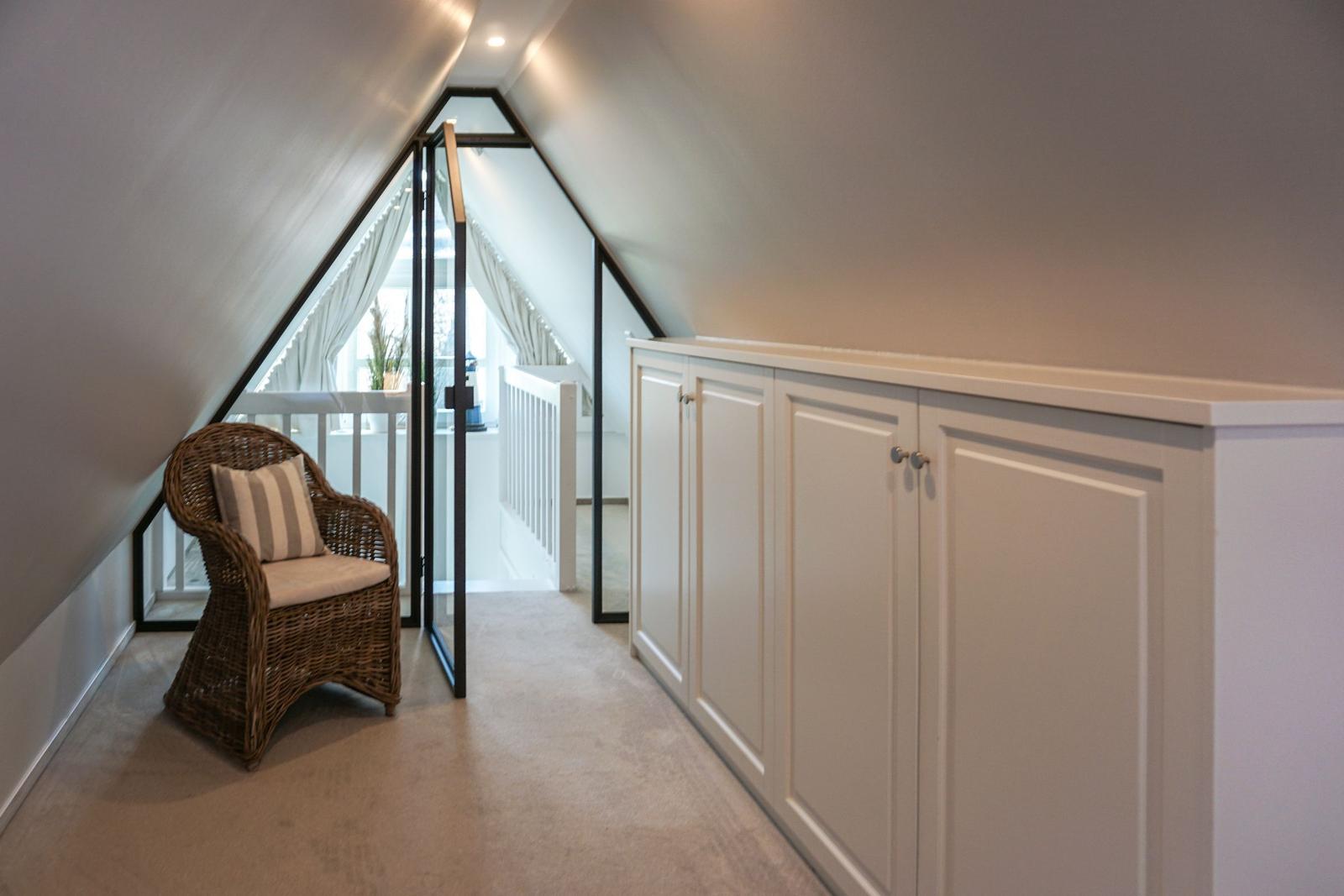 Attic with chair, cabinet, and glass sliding door to terrace.