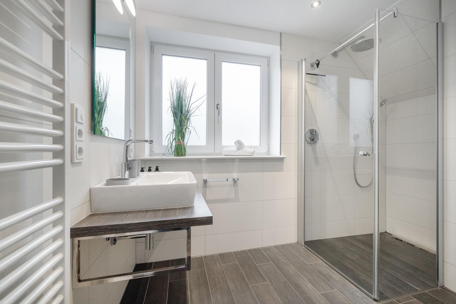 Bathroom with shower, sink, and window