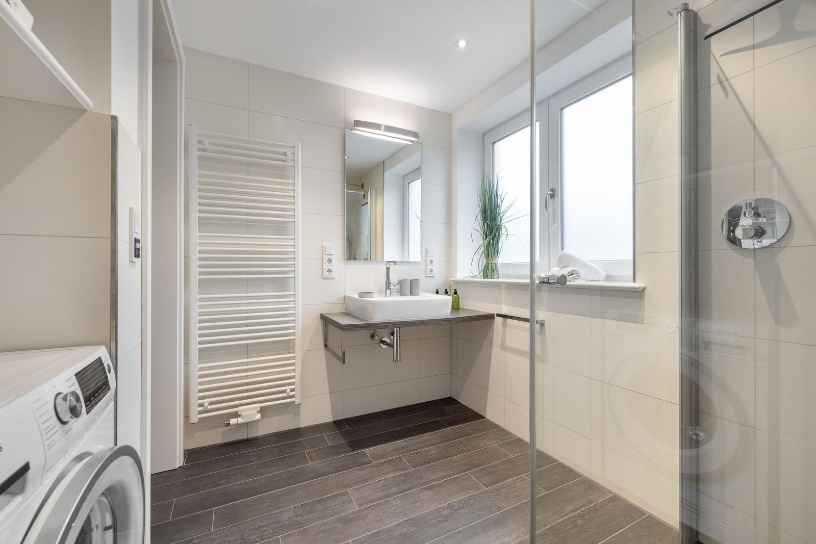 Bathroom with shower, sink, and heater.