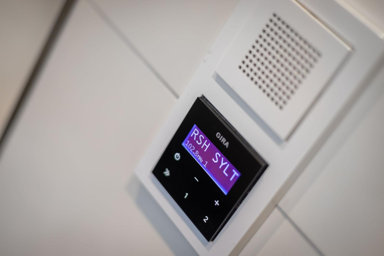 FM radio with display shows frequency and station name.