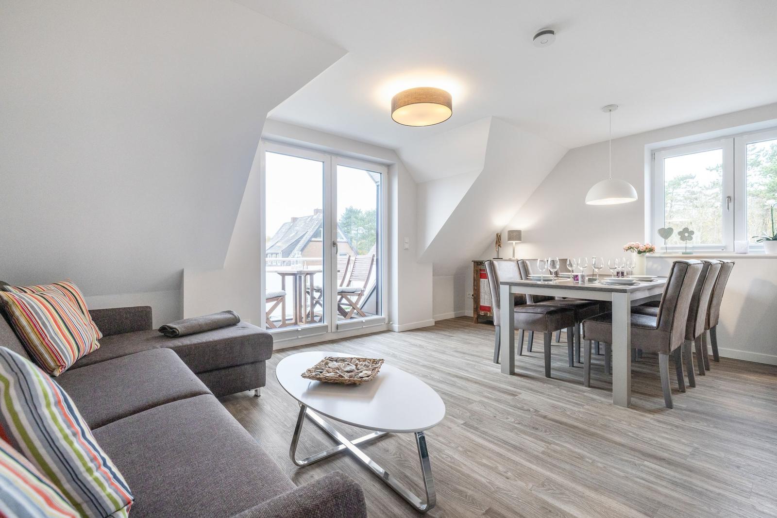 Living and dining area with balcony access and wooden floor