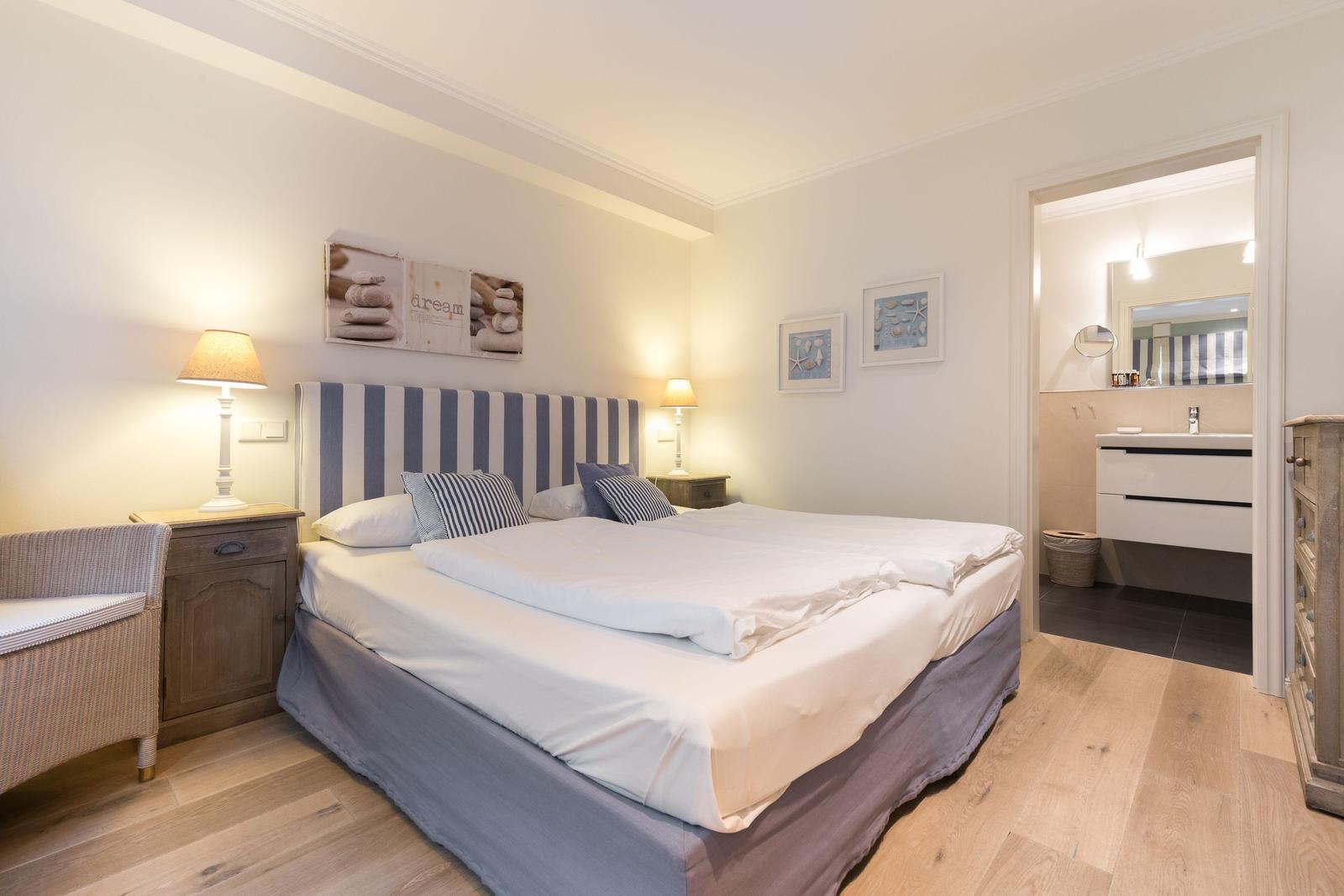 Bedroom with double bed, nightstands, and attached bathroom.