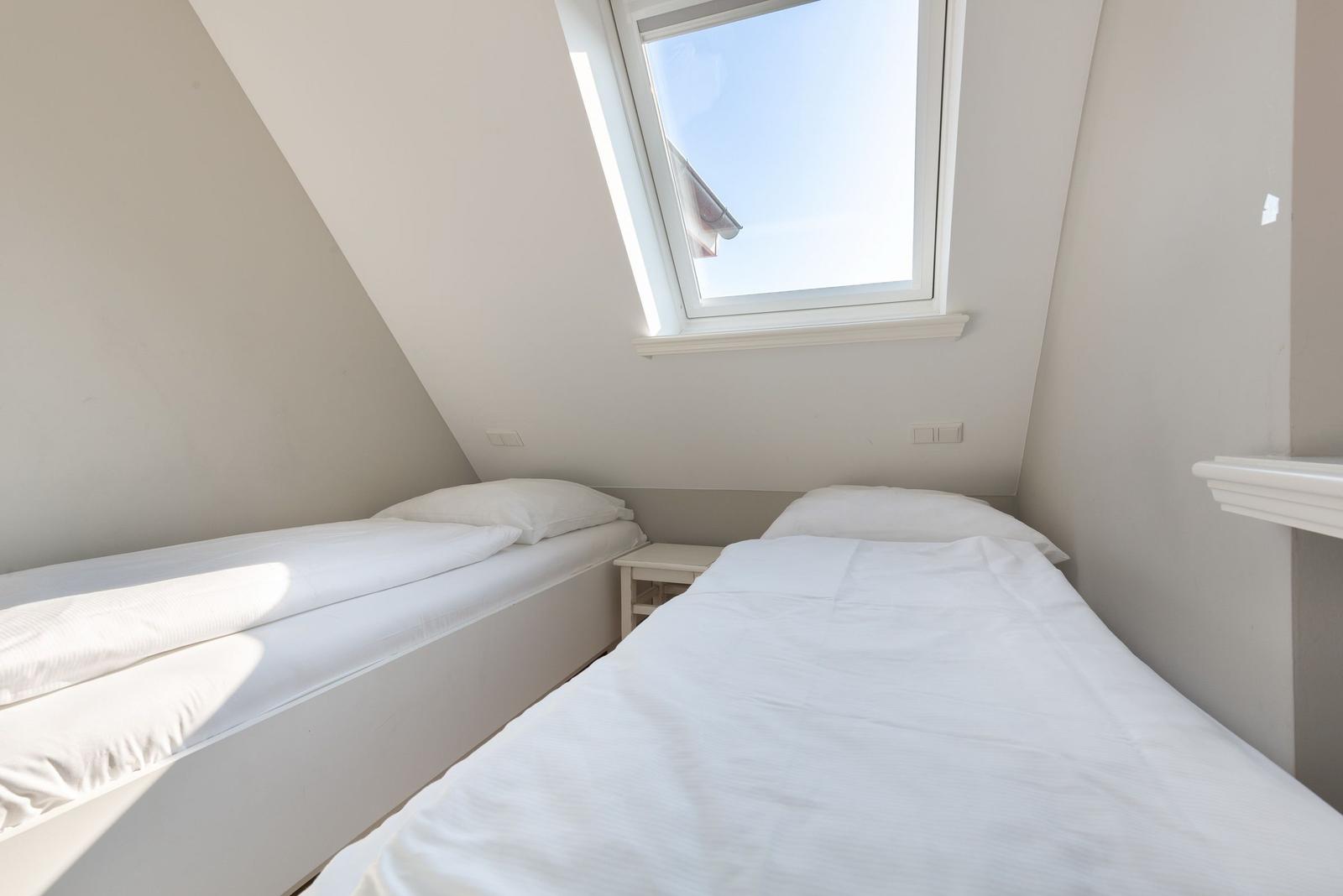 Zimmer mit zwei Einzelbetten und Dachfenster