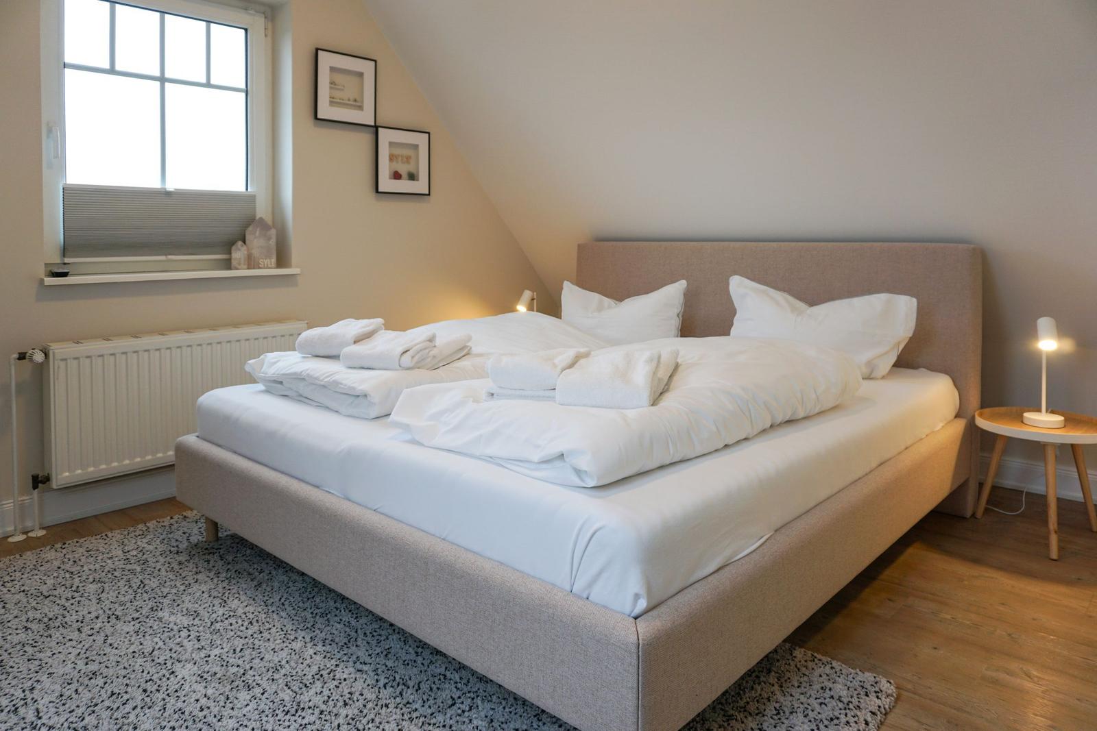Bedroom with bed, window, and nightstand