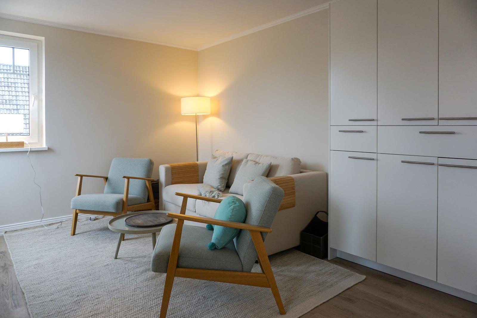 Living room with sofa, two chairs, and a floor lamp.