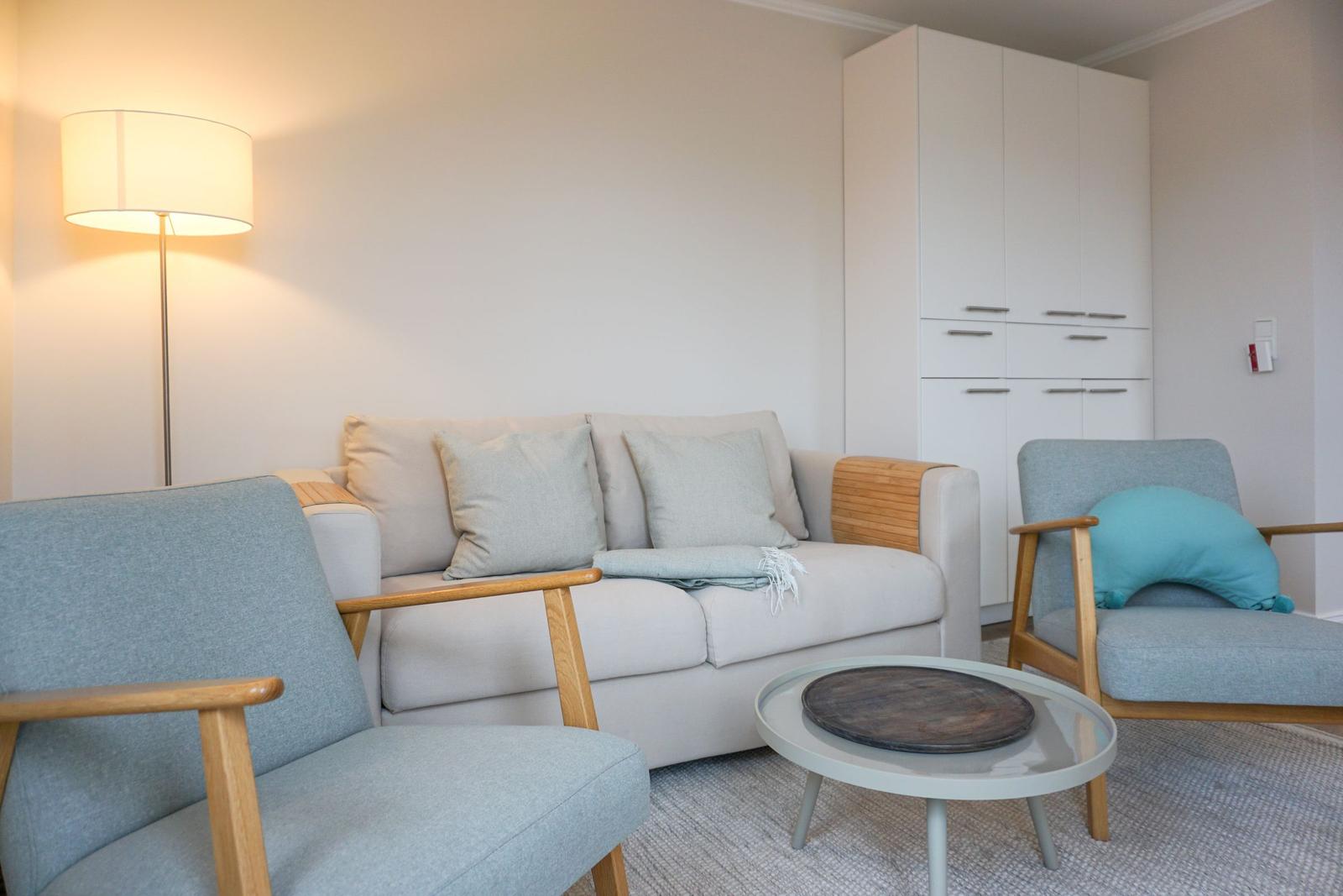 Living room with sofa, two chairs, and small table.