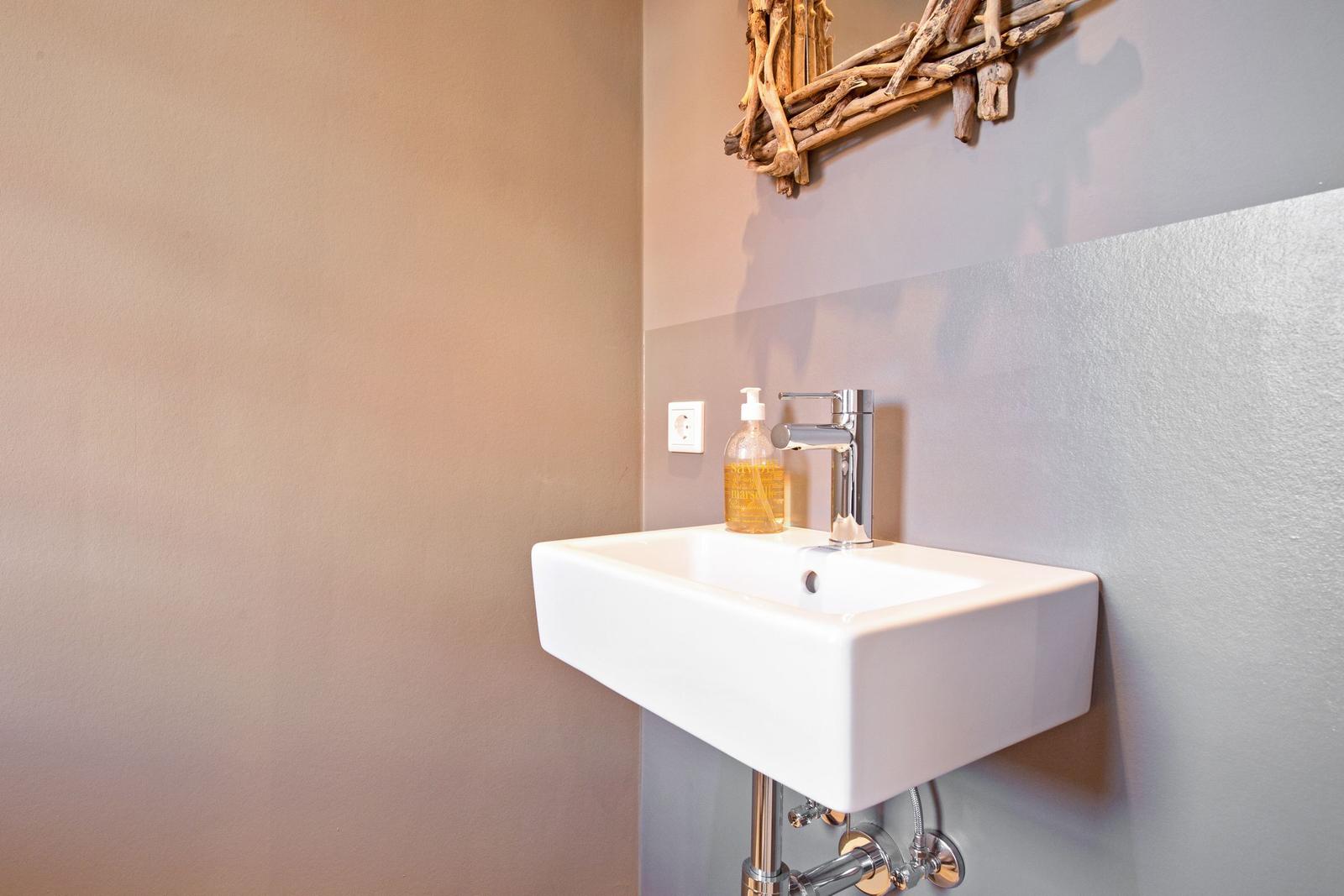 Sink with faucet and soap on the wall