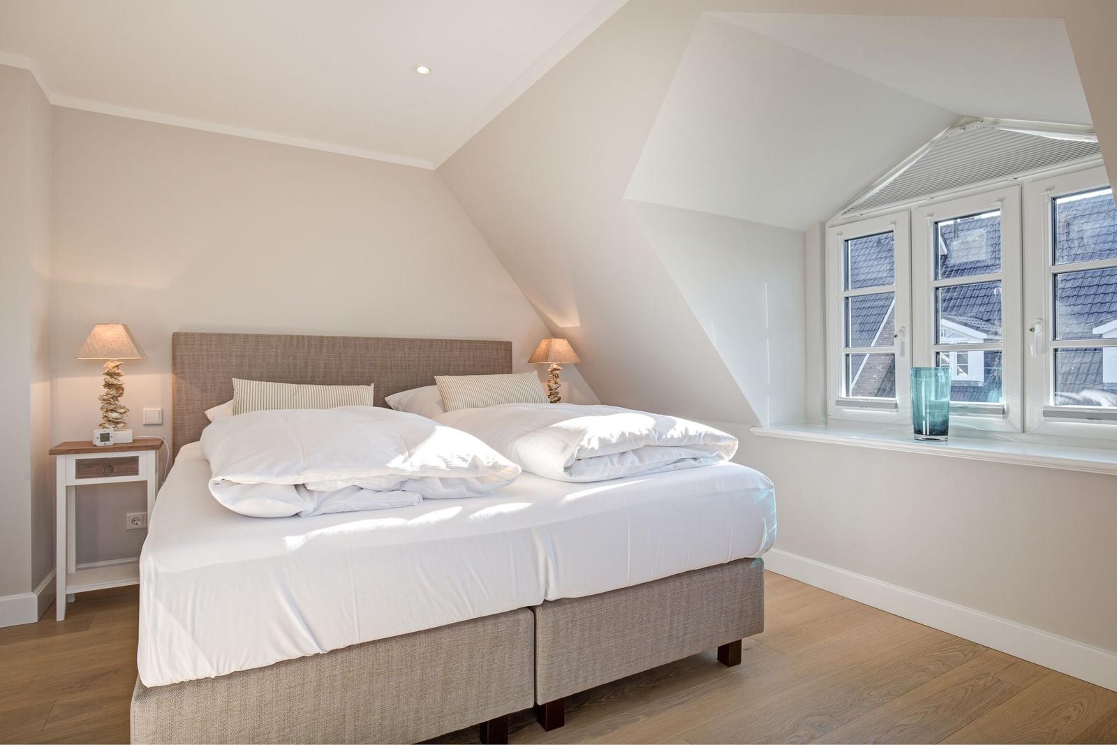 Bedroom with double bed, window, and nightstands.