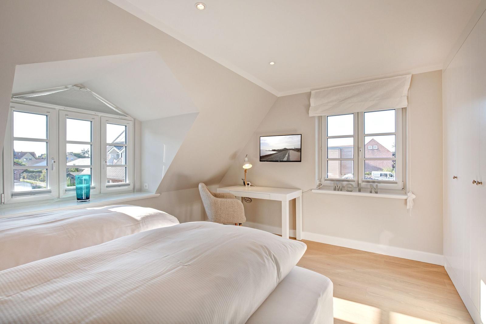 Bedroom with double bed, desk, and windows