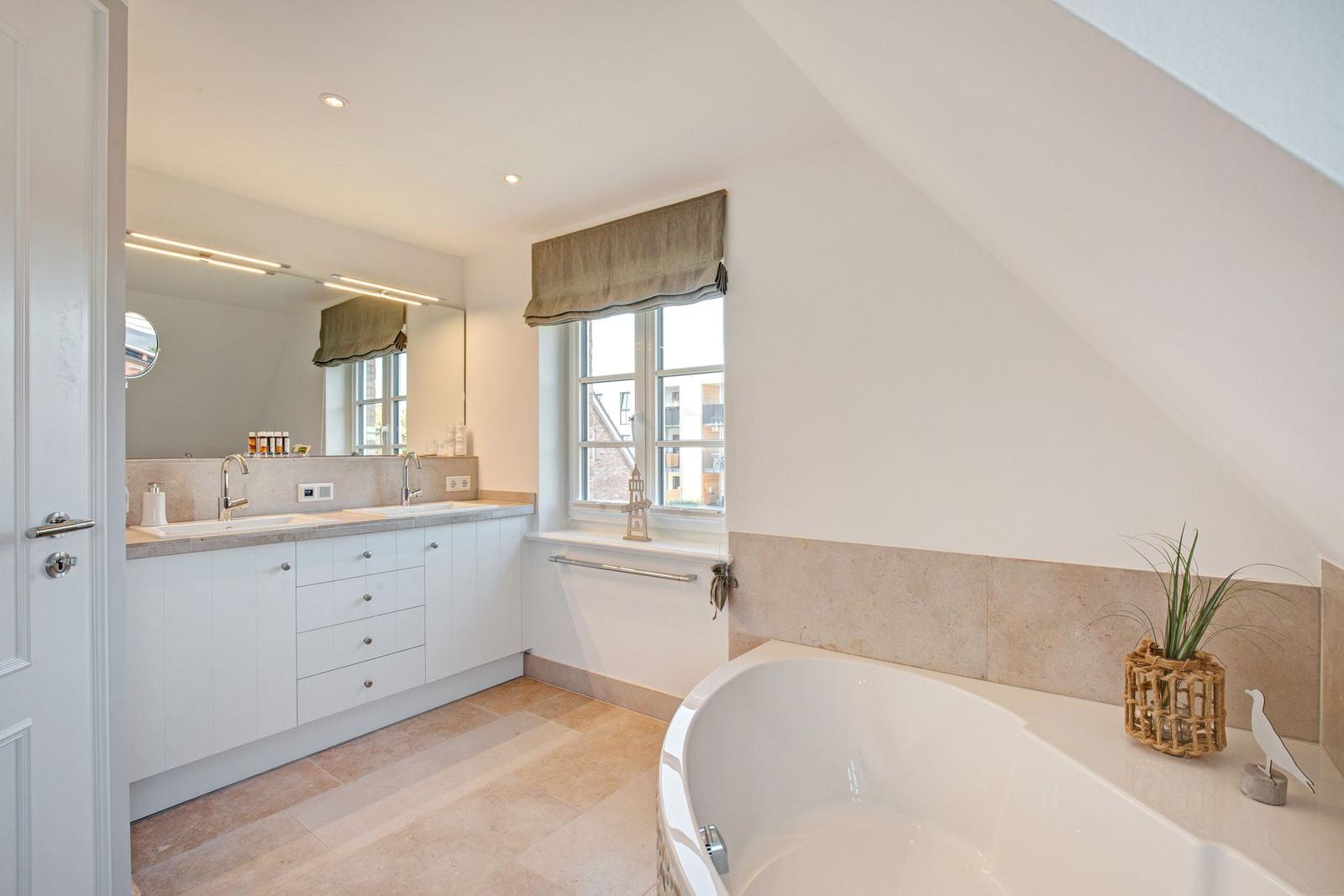 Bathroom with bathtub, sink, and window