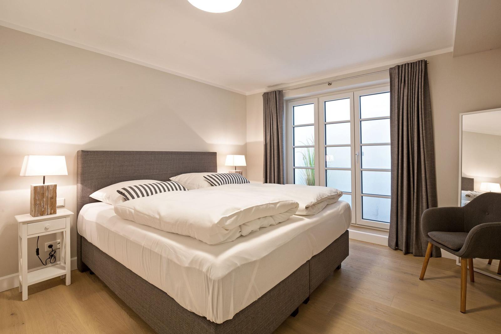 Bedroom with double bed, window, and chair.