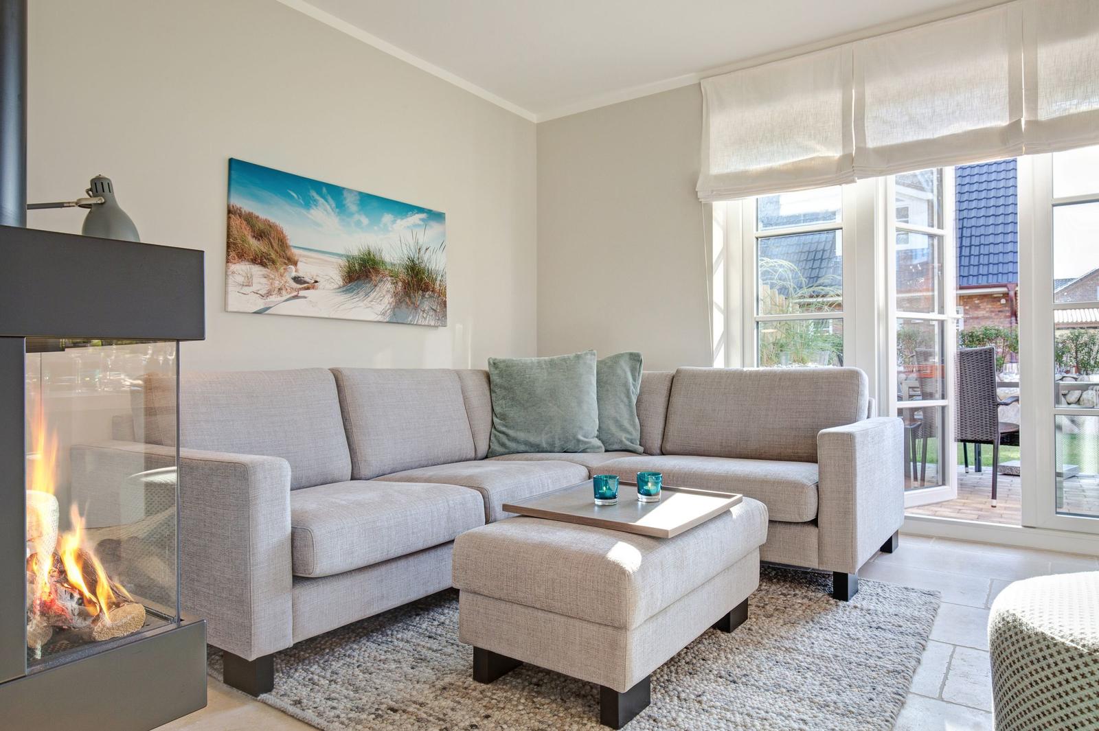 Living room with sofa, fireplace, and view of the terrace.