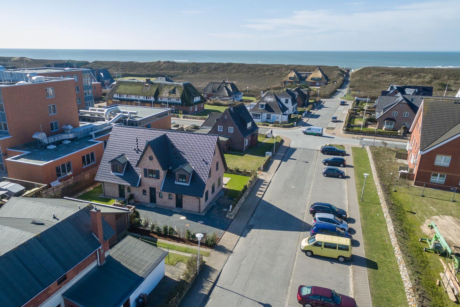 Aussicht auf Stranddorf mit Häusern und Parkplatz