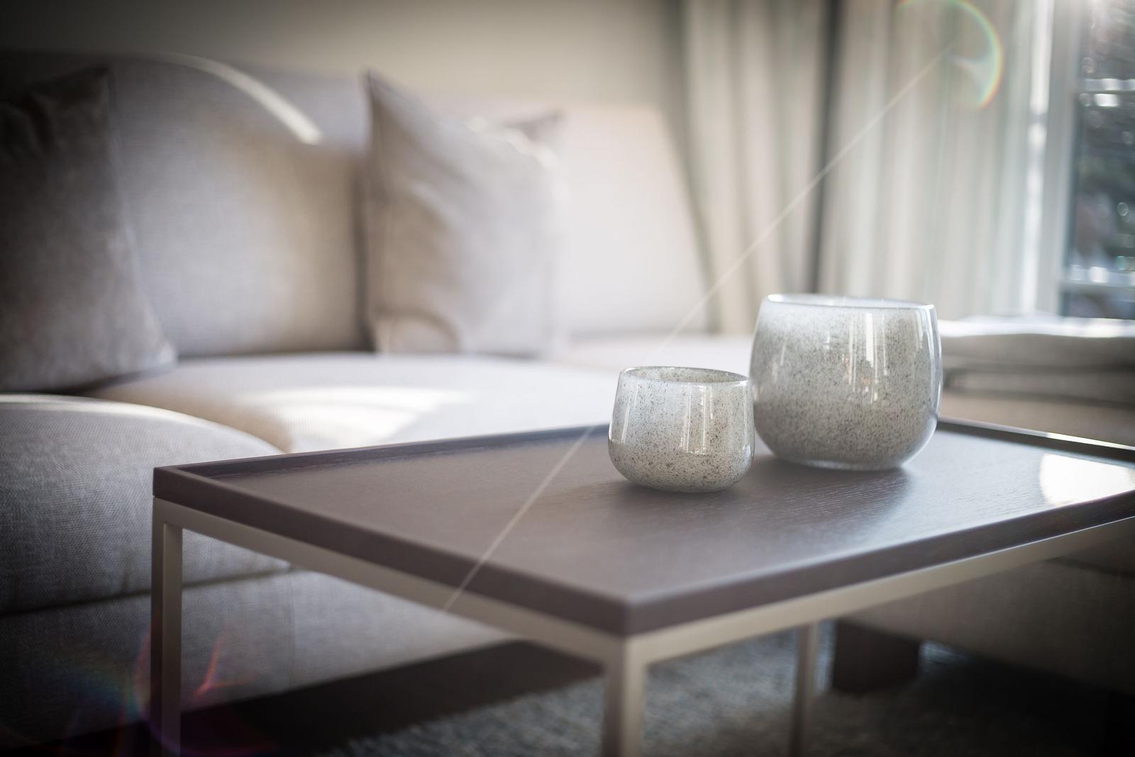 Tisch mit zwei Keramikgefäßen vor einem Sofa