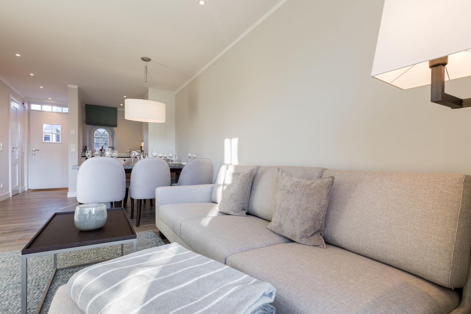 Wohnzimmer mit Sofa, Couchtisch und Blick in die Essnische.