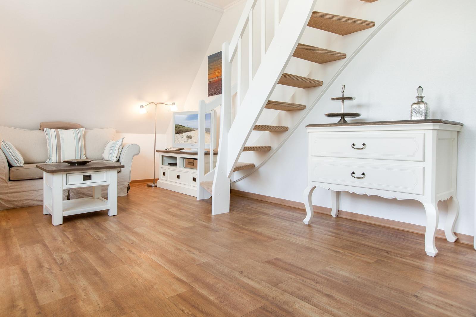 Living room with sofa, table, and cabinet under staircase.
