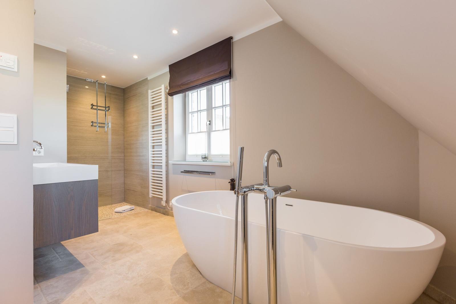 Bathroom with freestanding bathtub, shower, and window