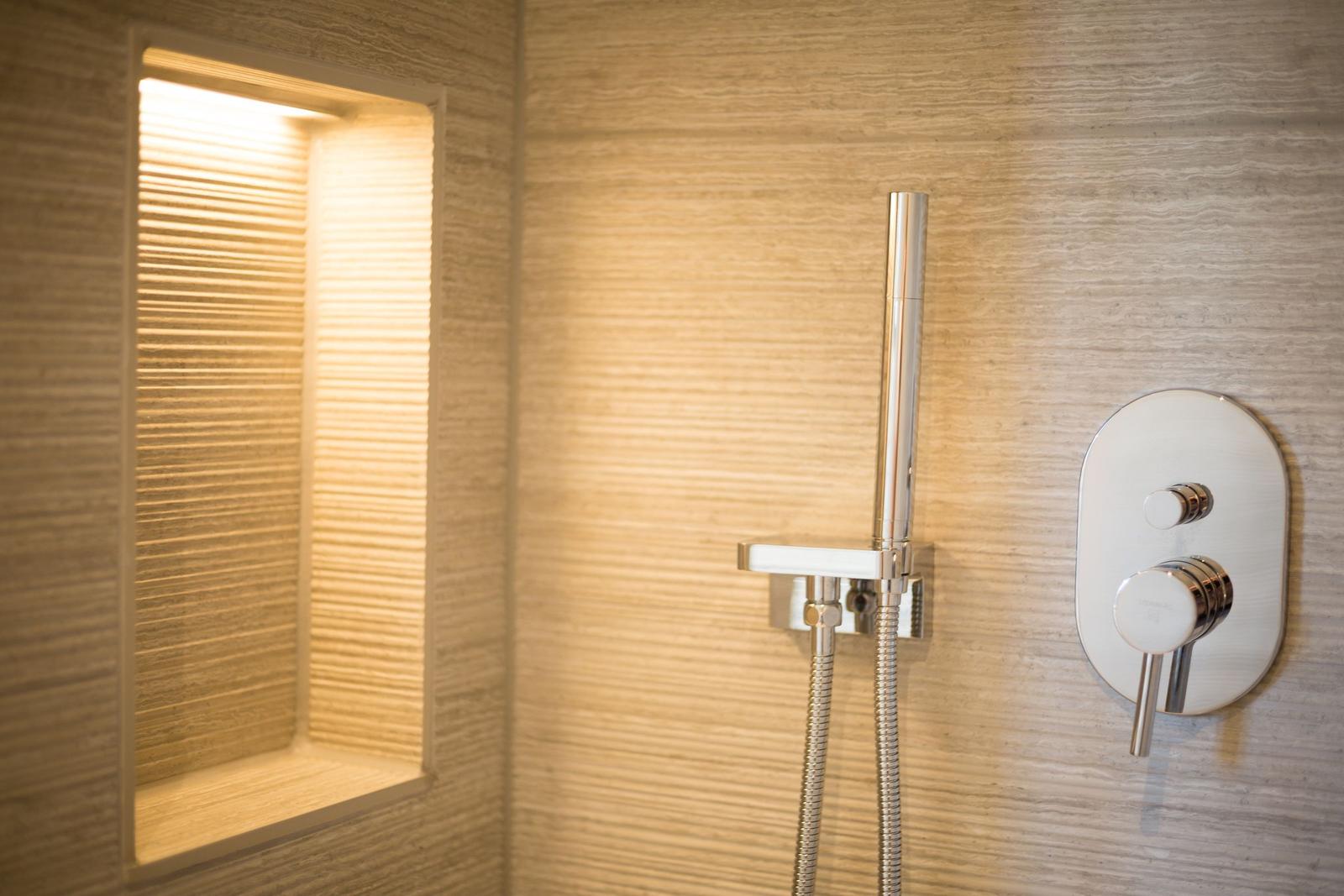 Shower area with modern shower and lit niche.