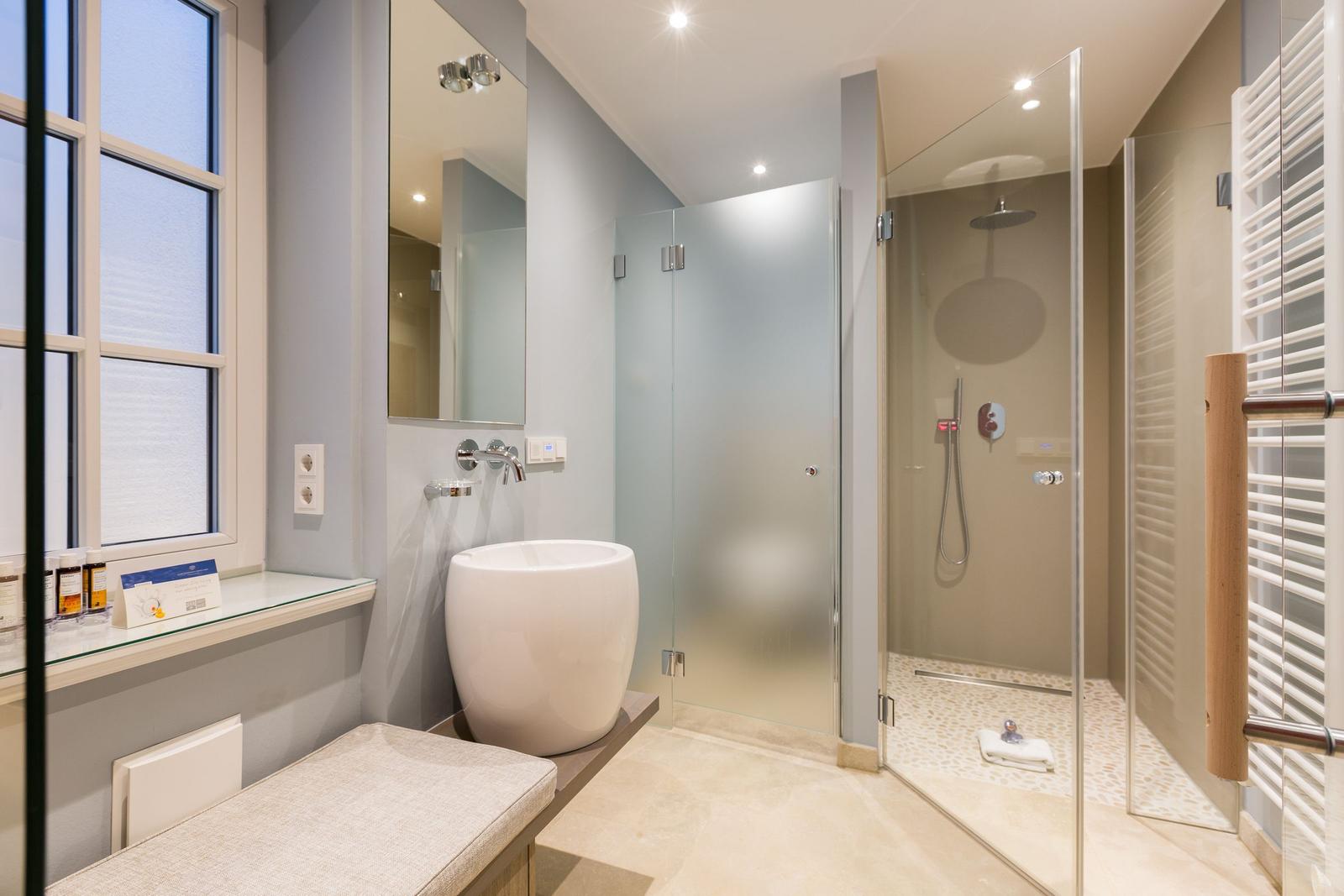 Bathroom with shower, sink, and window