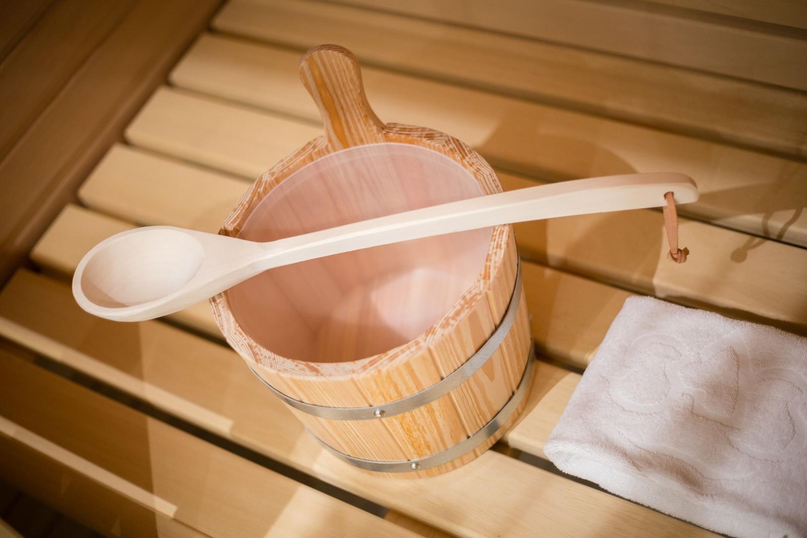 Wooden bucket with ladle and towel on bench