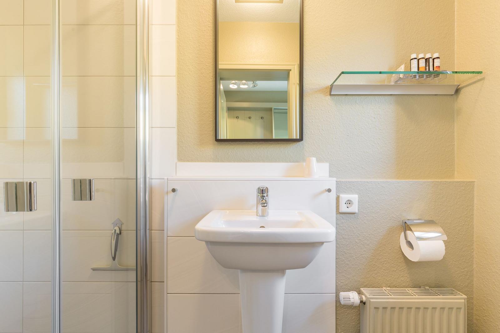 Bathroom with shower, sink, and mirror