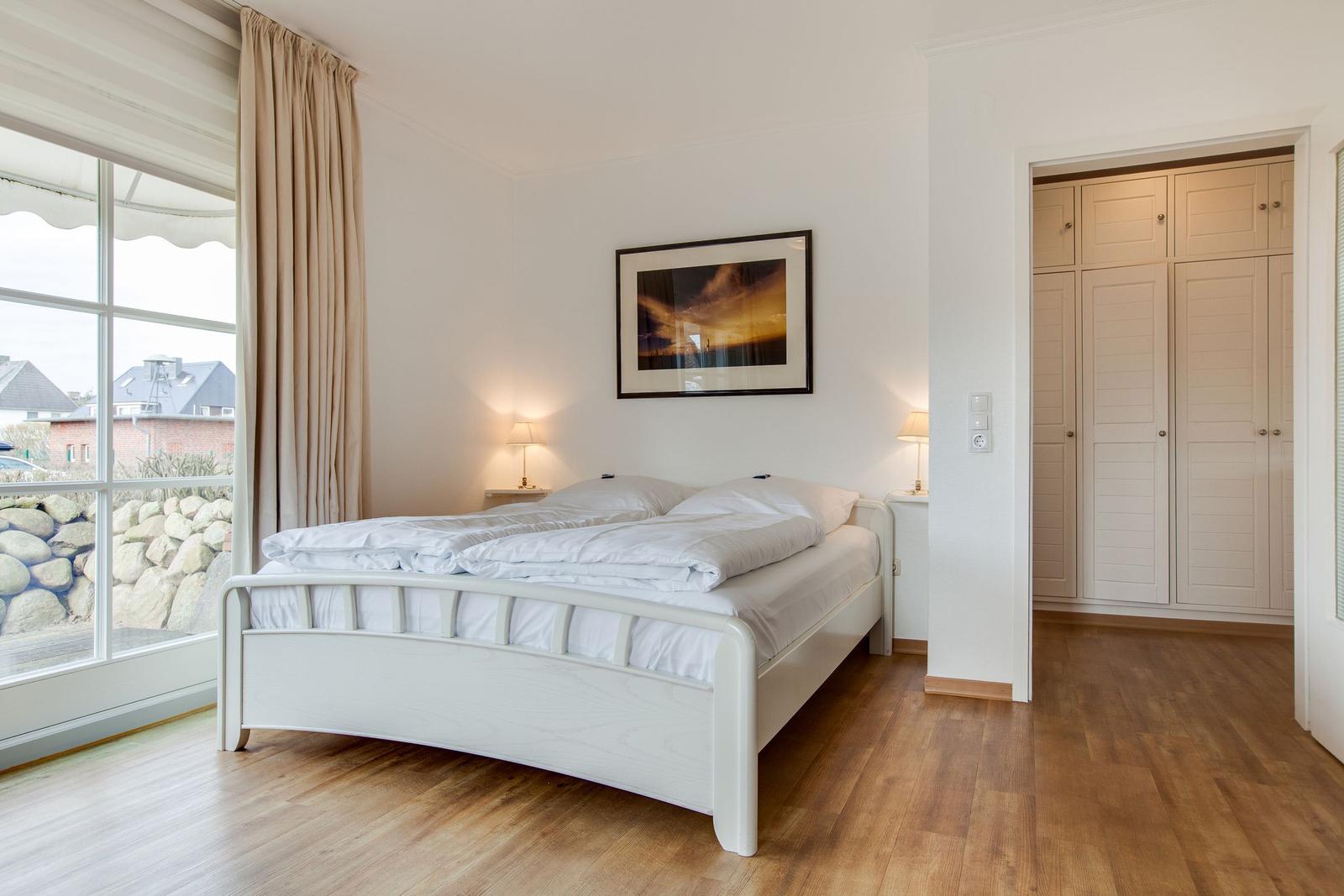 Bedroom with double bed, wardrobe, and large window with view.