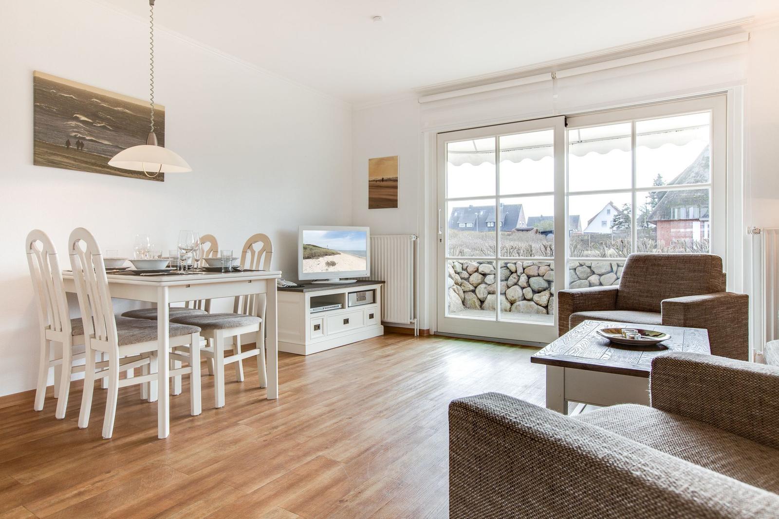 Living and dining area with view of the beach and stone barrier.
