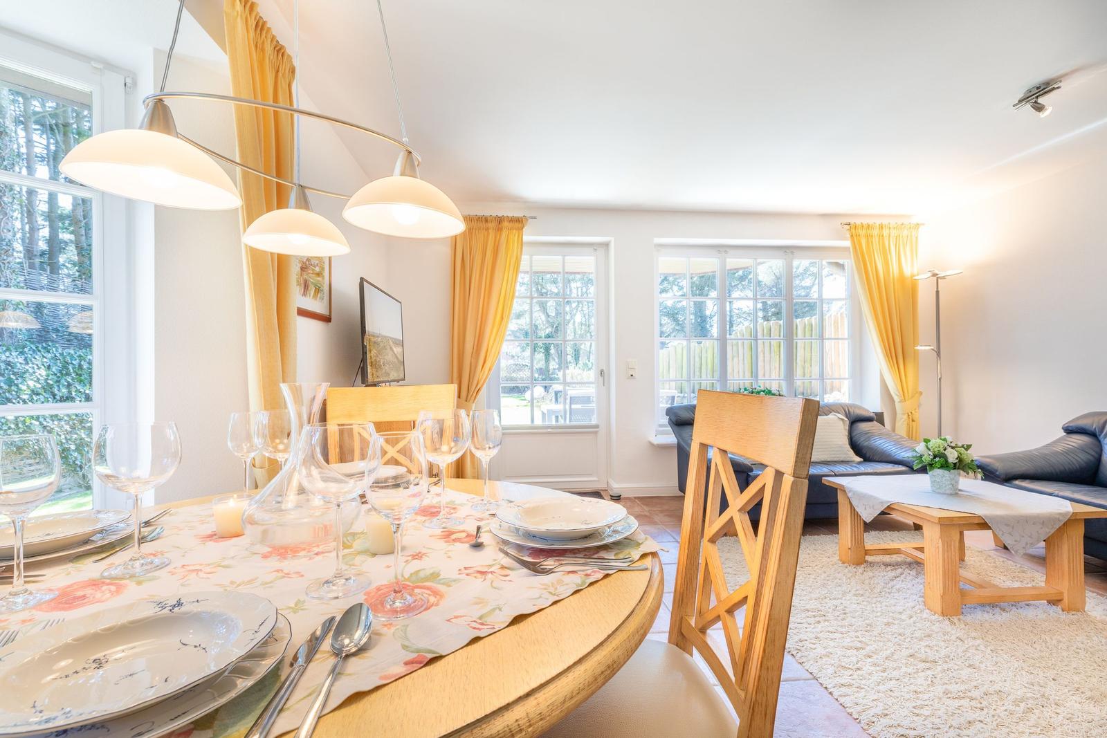 Dining table with chairs and windows in the living area.
