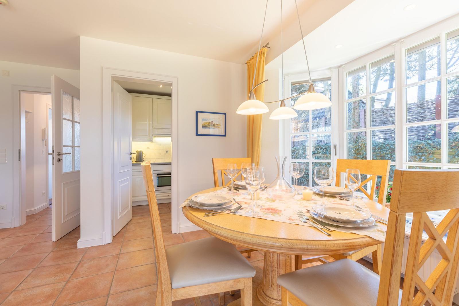 Dining room with wooden table, chairs, and view of garden