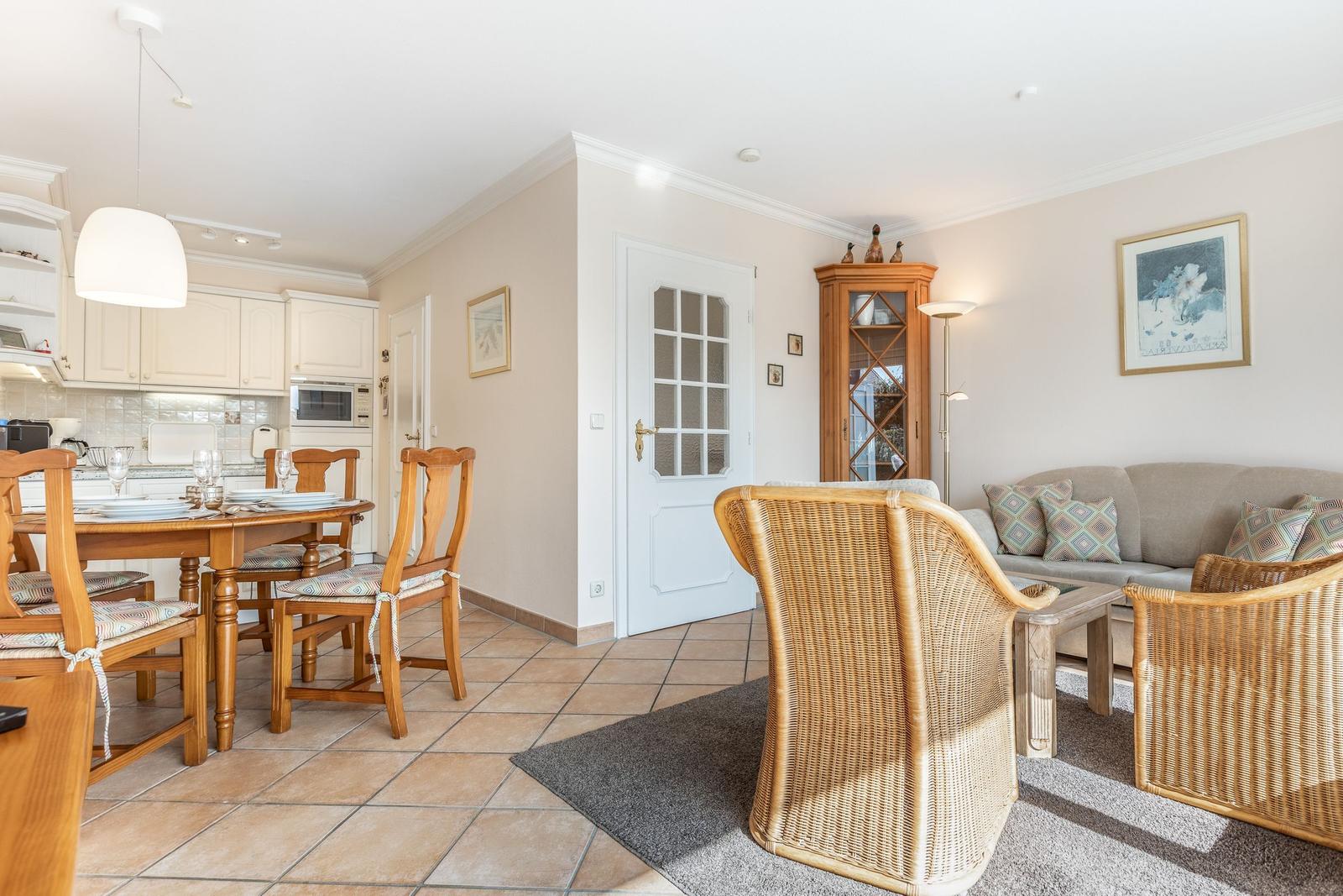 Living and dining area with wooden table, chairs, and sofa.