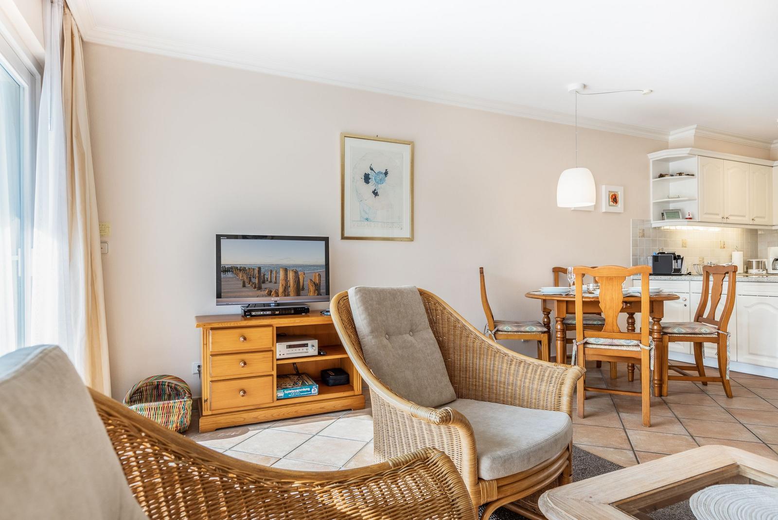 Living and dining area with TV, chair, and table.