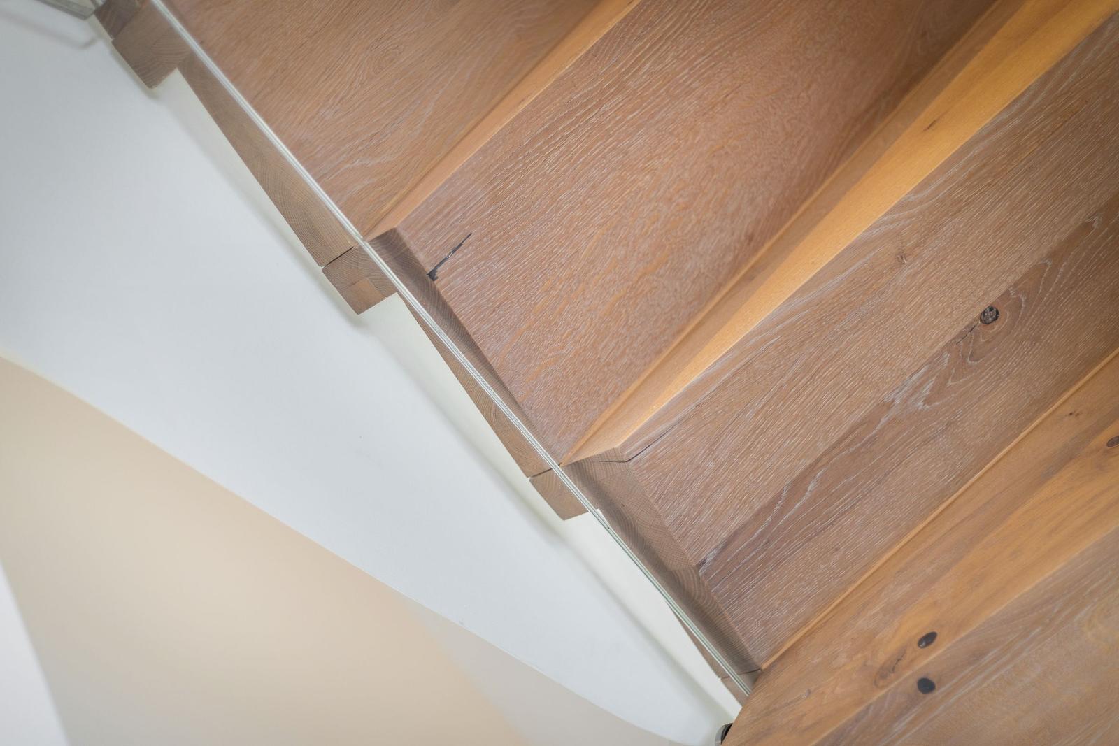 Holzgetreppe mit sichtbaren Nähten und natürlichen Maserungen an der Wand