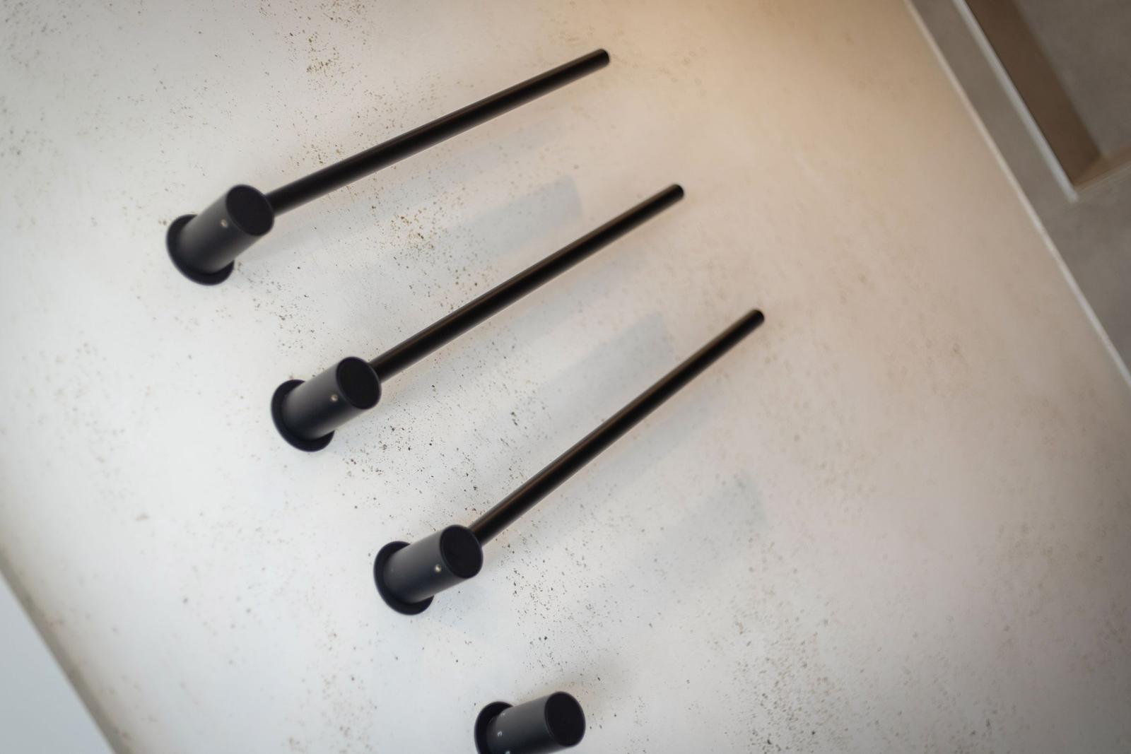 Drei schwarze Handläufe an einer hellen Wand