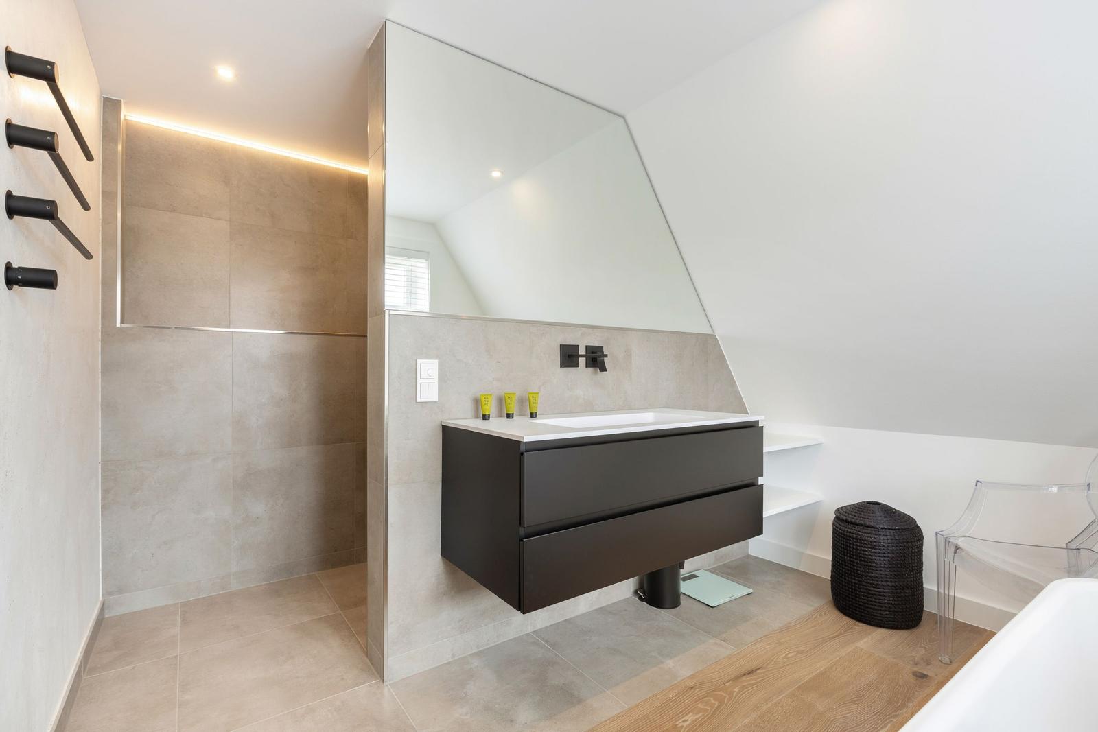Moderne Dusche mit schwarzen Armaturen und Spiegelschrank mit Waschbecken