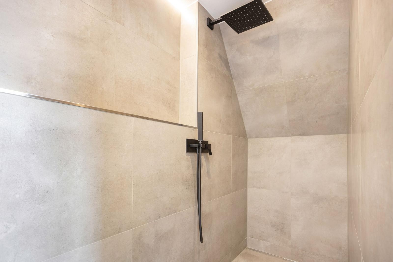 Dusche mit Duschbrause und Handbrause an Wand