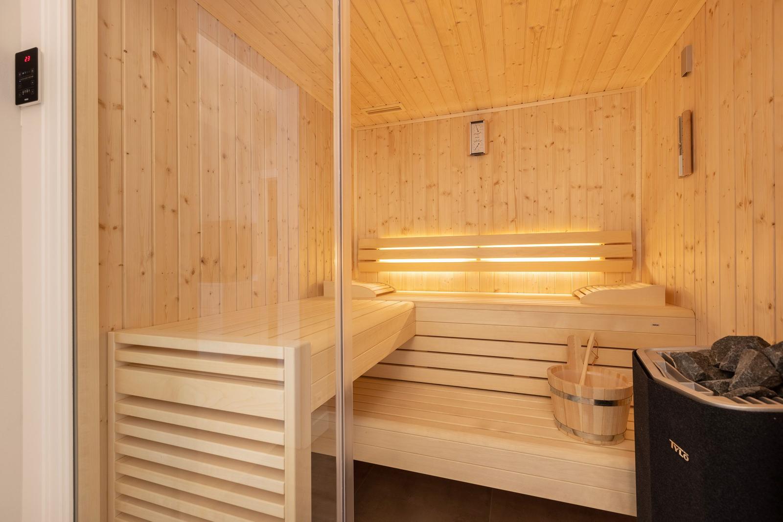 Sauna mit Holzbank, Holzwanne und Steine