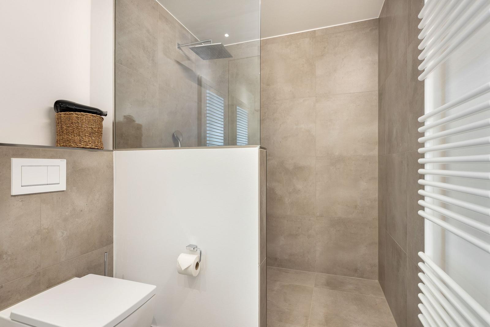 Bad mit Dusche, Toilette und Heizkörper