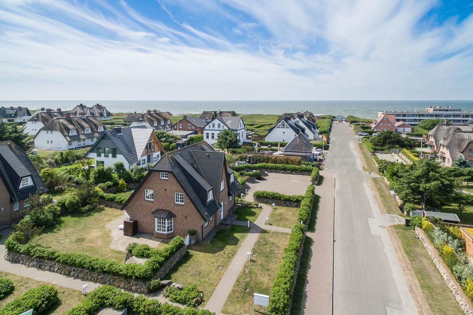 Village street with houses and view of the sea