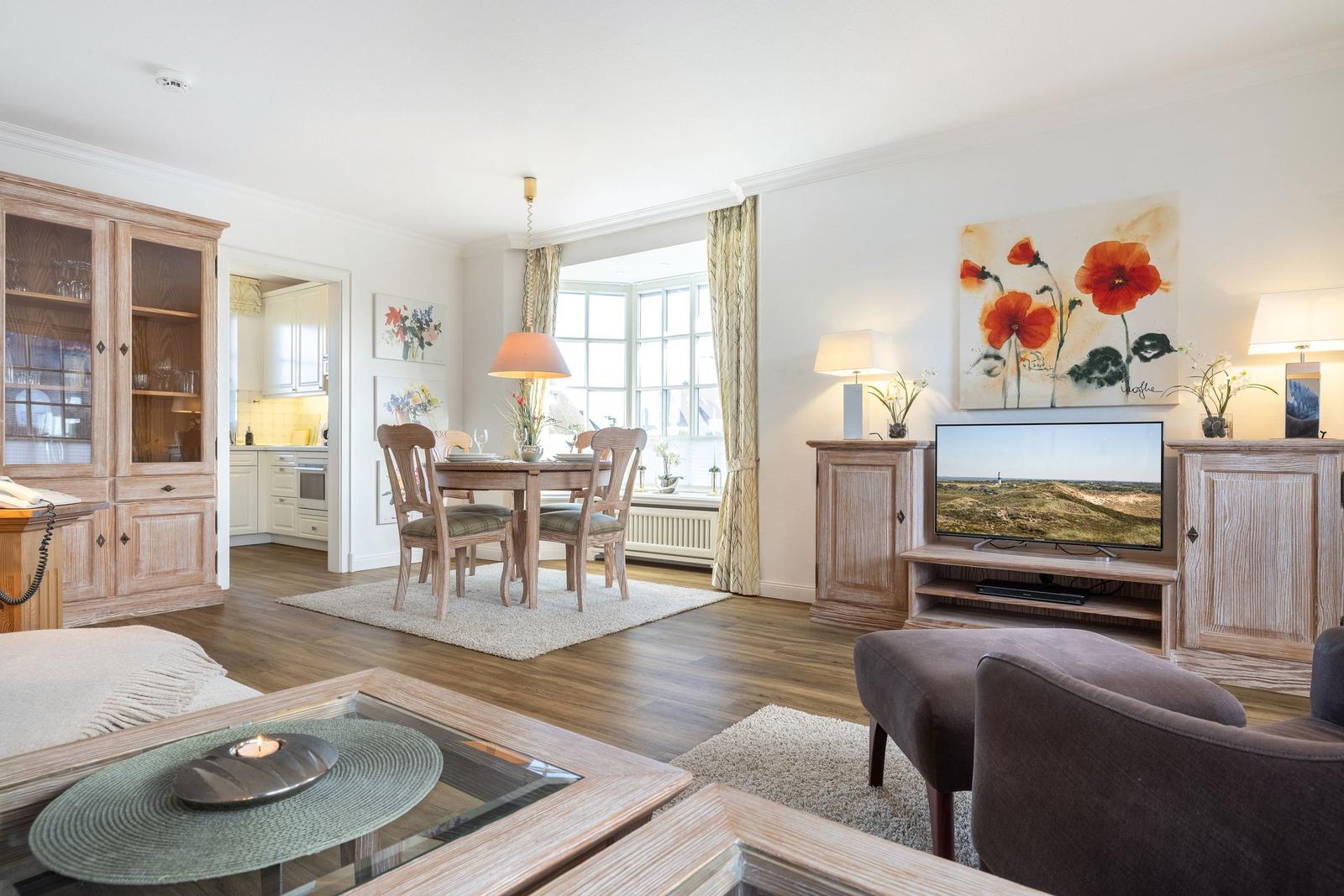 Living and dining area with wooden furniture, TV, and window.