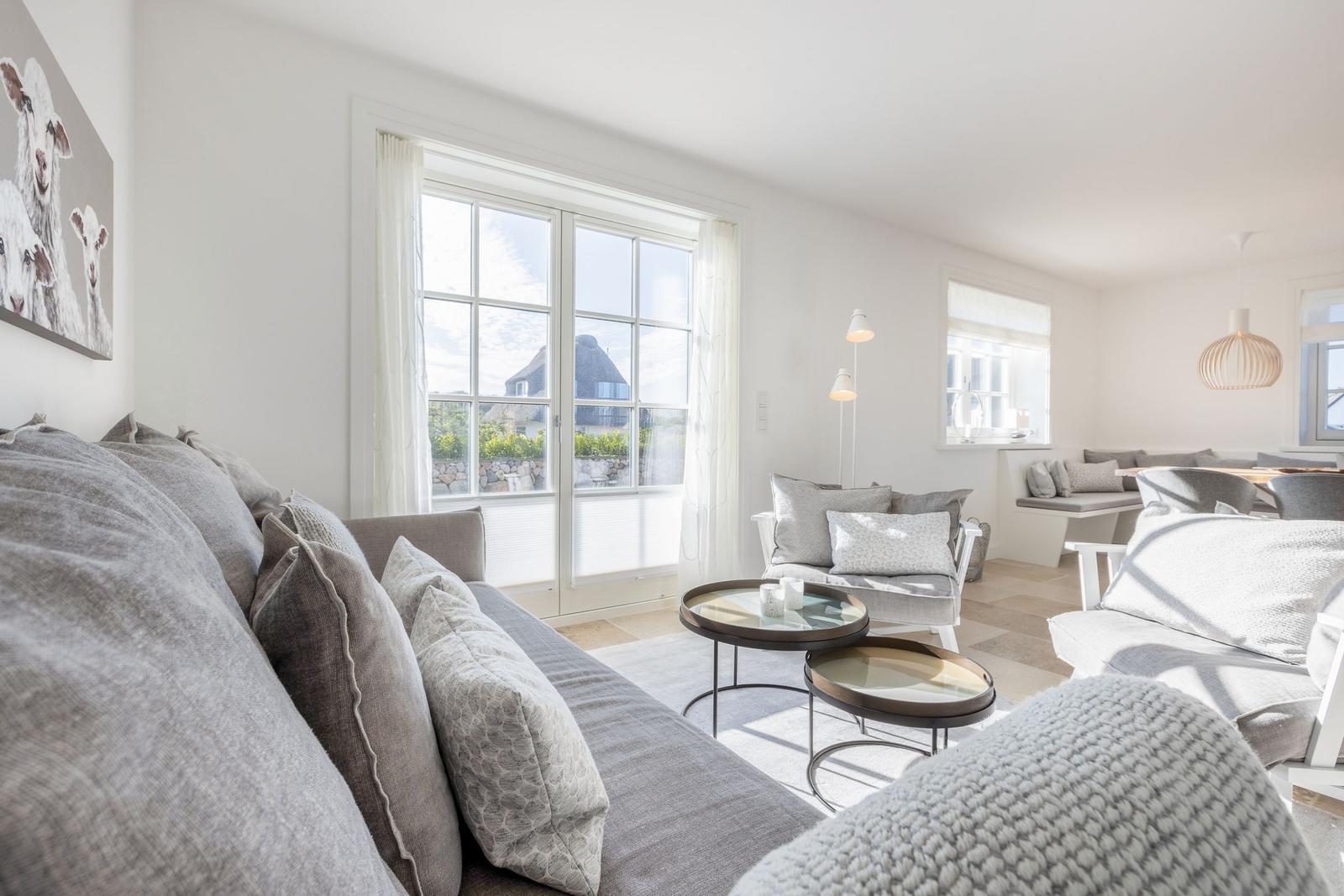 Living area with sofa, seating, and window view.