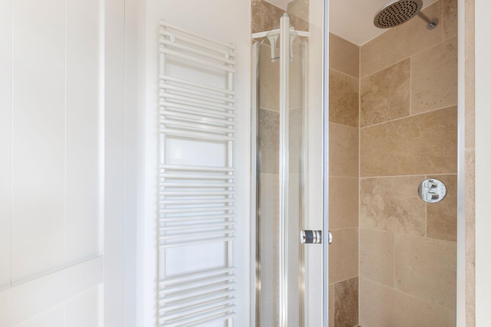 Shower enclosure with glass door and heater on the wall