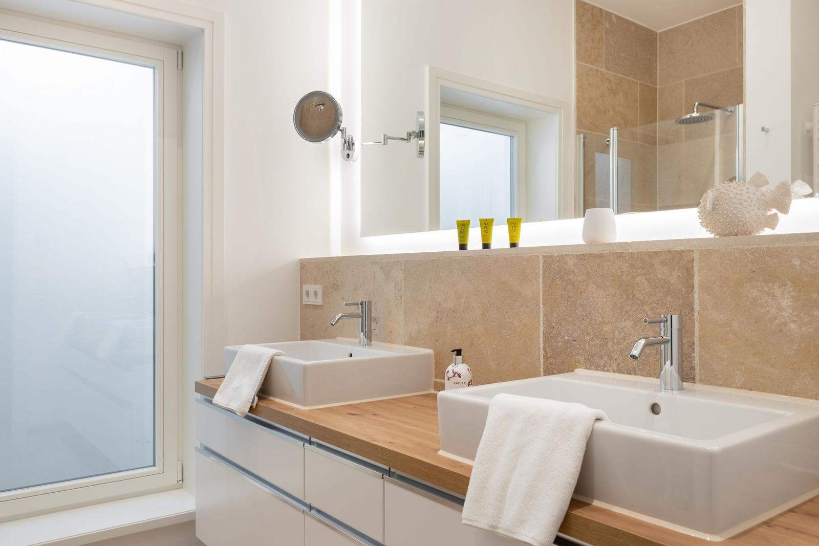 Bathroom with two sinks, wooden countertop, and floor-to-ceiling mirror