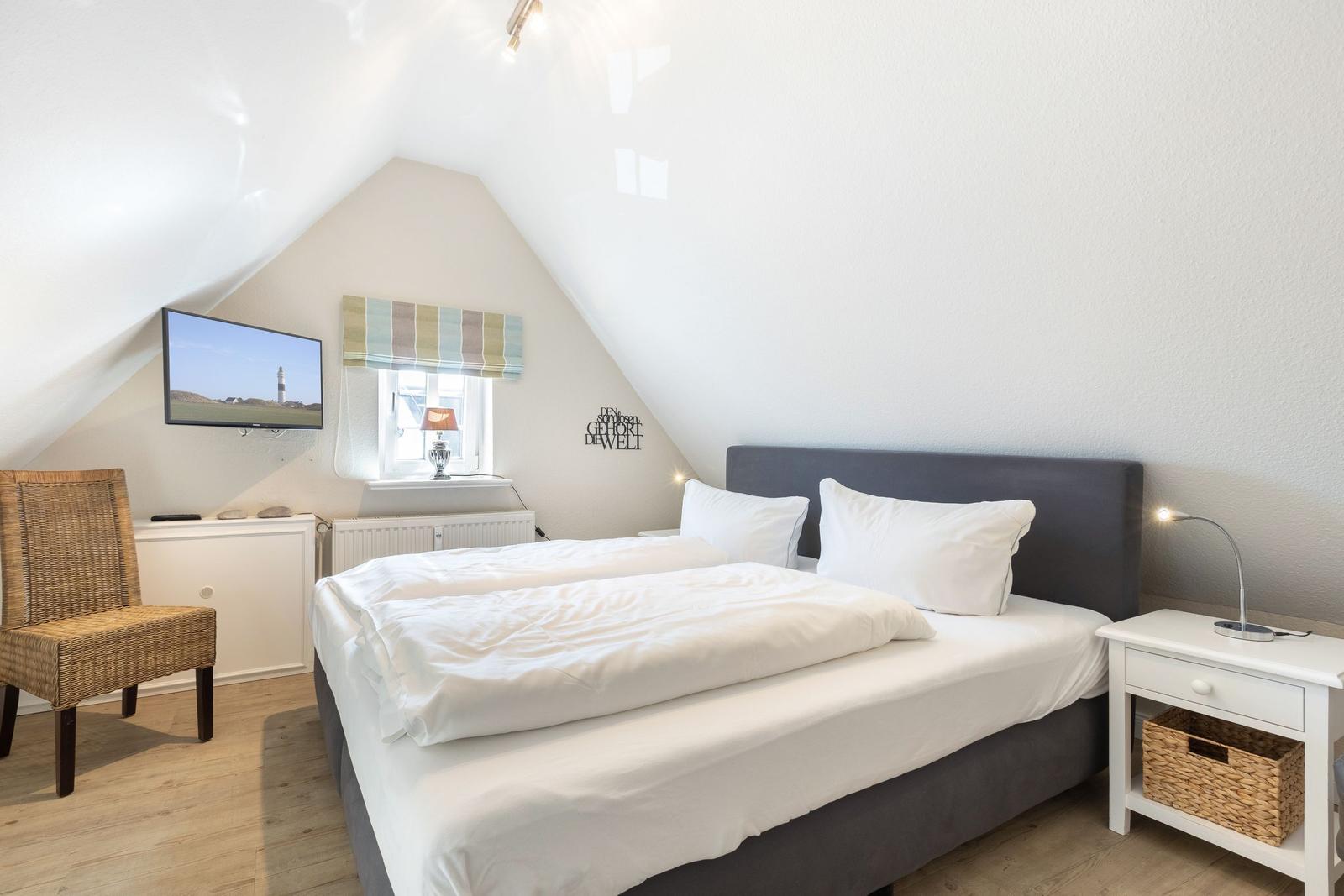 Bedroom with double bed, TV, and window.